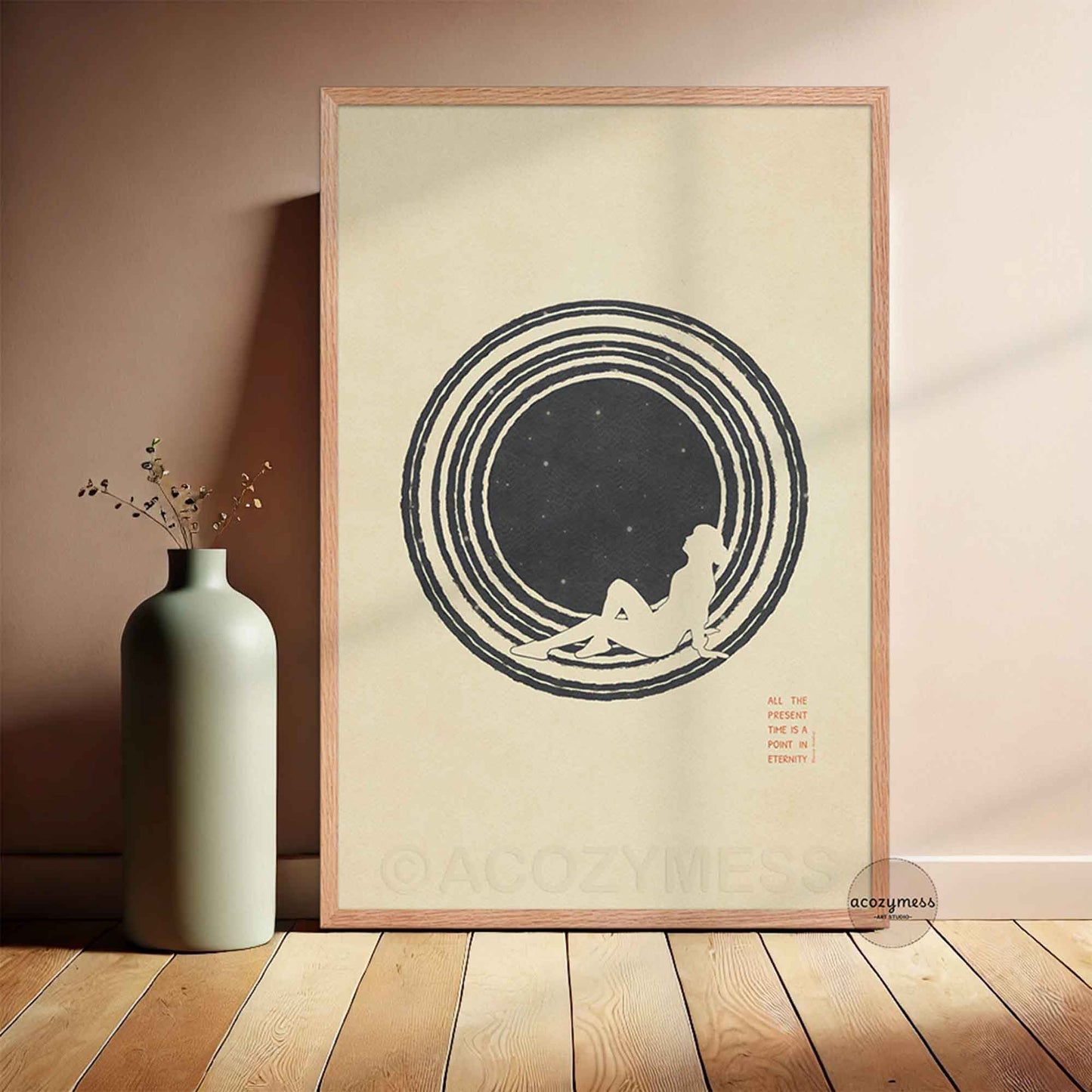 A minimalist Stoic art poster framed in a light oak wood frame, leaning against a wall on a light hardwood floor. The artwork features a clean, stylized illustration of a person gazing up at a minimalist star-filled sky against a warm beige background. Elegant, vertical typography reads: "ALL THE PRESENT IS A POINT IN ETERNITY. Marcus Aurelius."