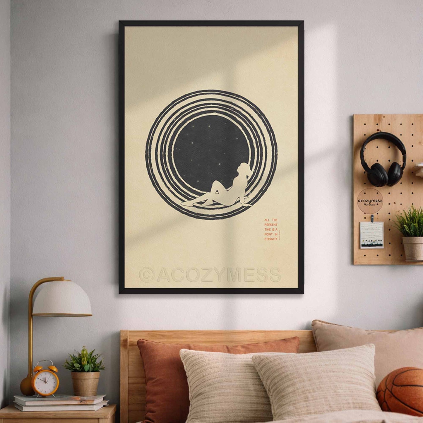 Framed minimalist Marcus Aurelius Stoic philosophy poster featuring a person gazing at stars illustration and the quote -All the present is a point in eternity, on a beige wall above a bed.