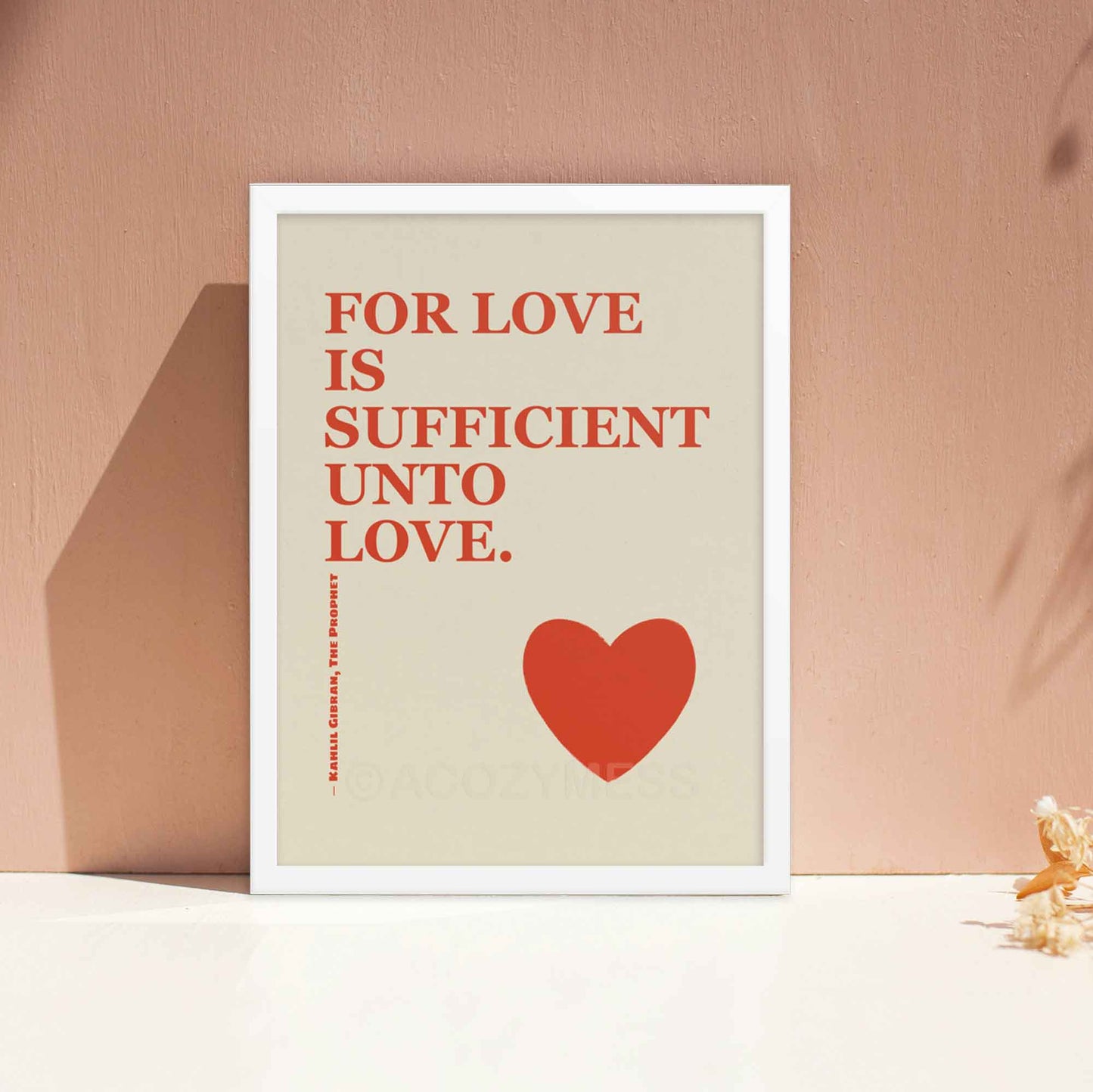 Kahlil Gibran poster with quote on love, red on beige with heart design, displayed in white frame.