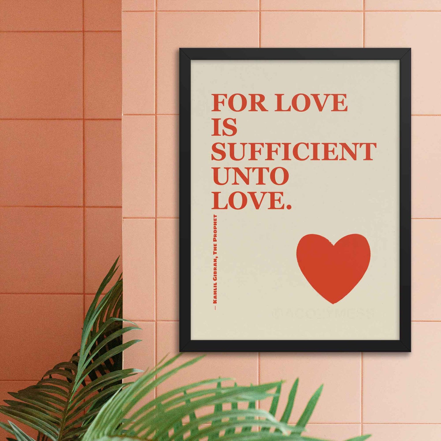 Kahlil Gibran poster with quote on love, red on beige with heart design, displayed in black frame.