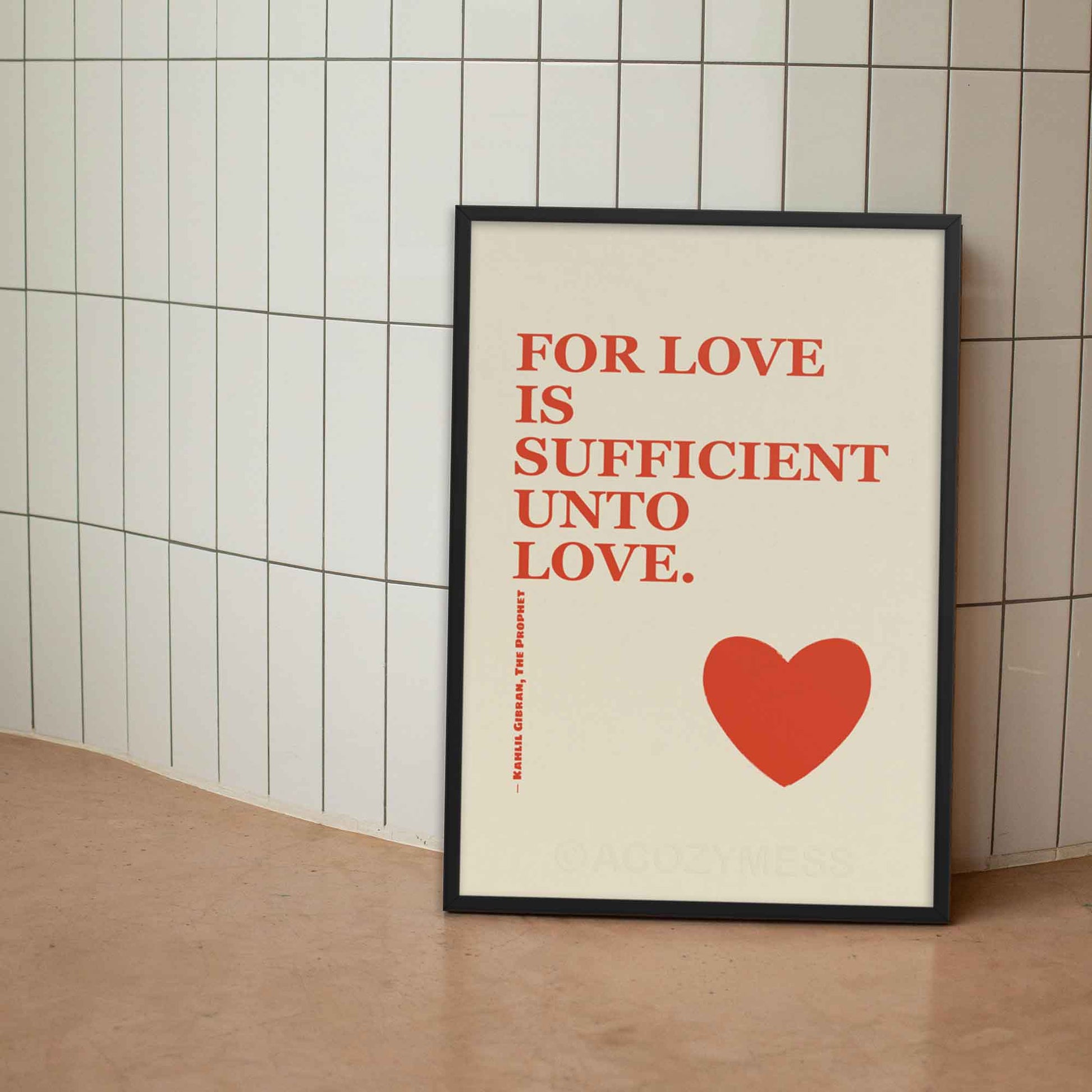 Kahlil Gibran poster with quote on love, red on beige with heart design, displayed in black frame.