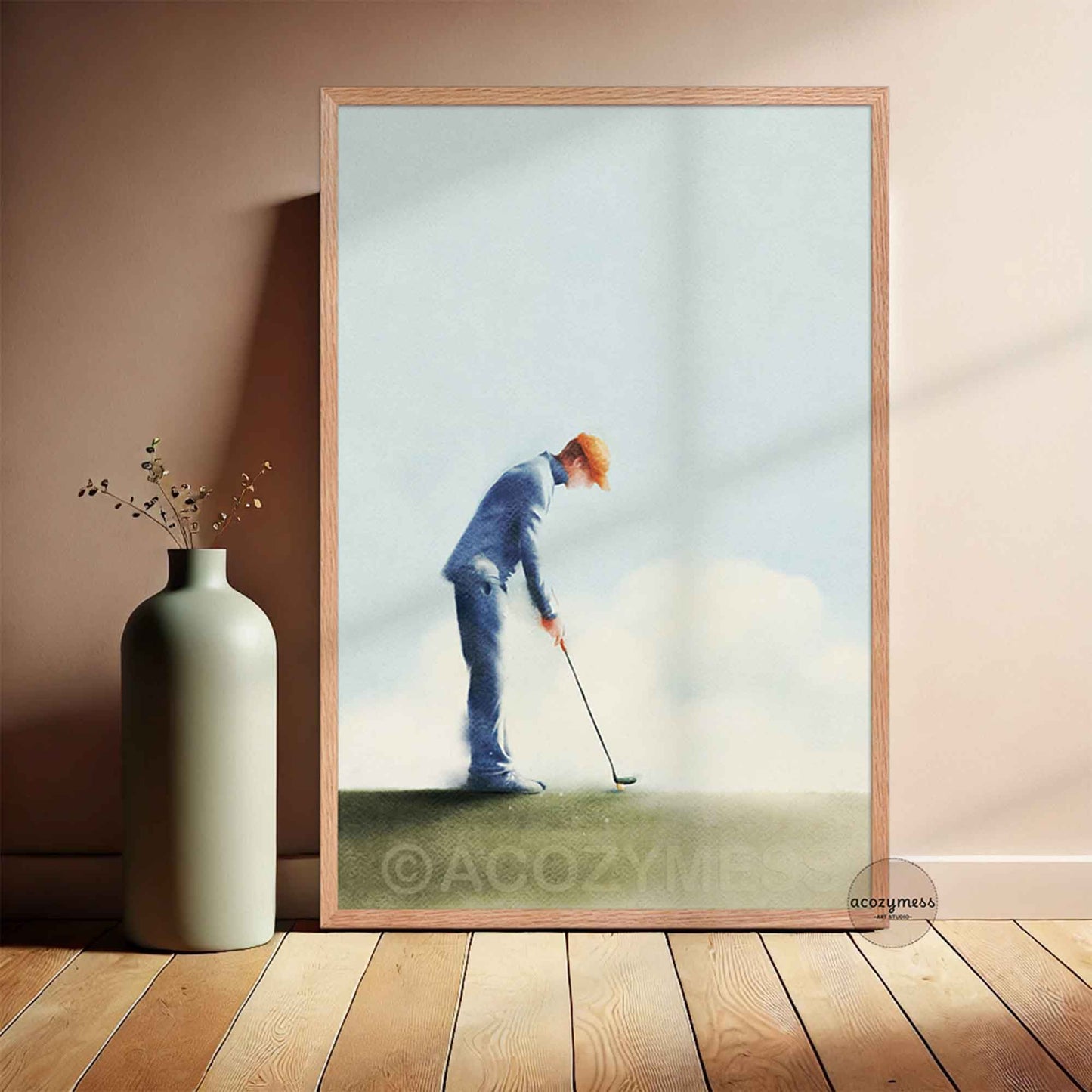 Framed artwork of a golfer on a wall next to a vase.