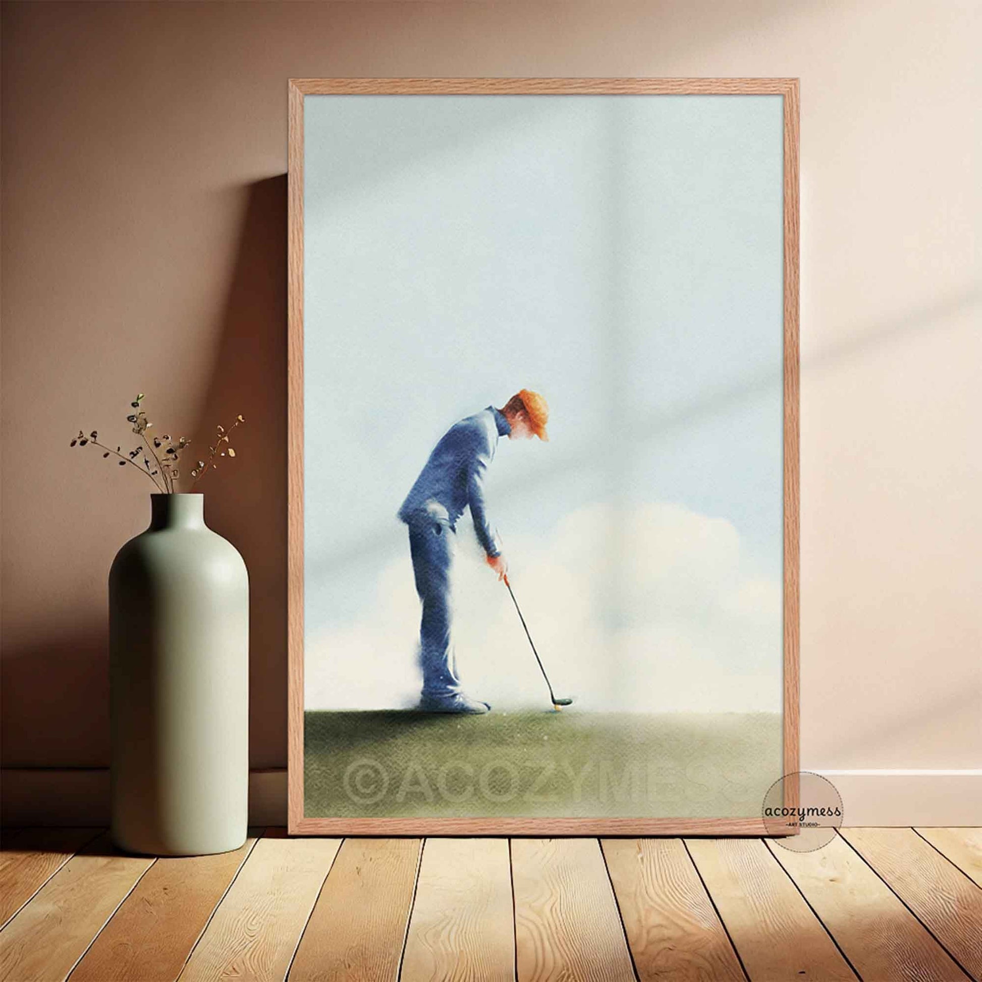 Framed artwork of a golfer on a wall next to a vase.