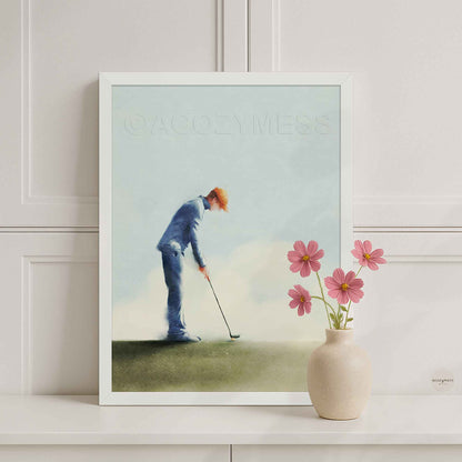 White Framed artwork of a golfer on a golf course with a vase of flowers on a shelf.