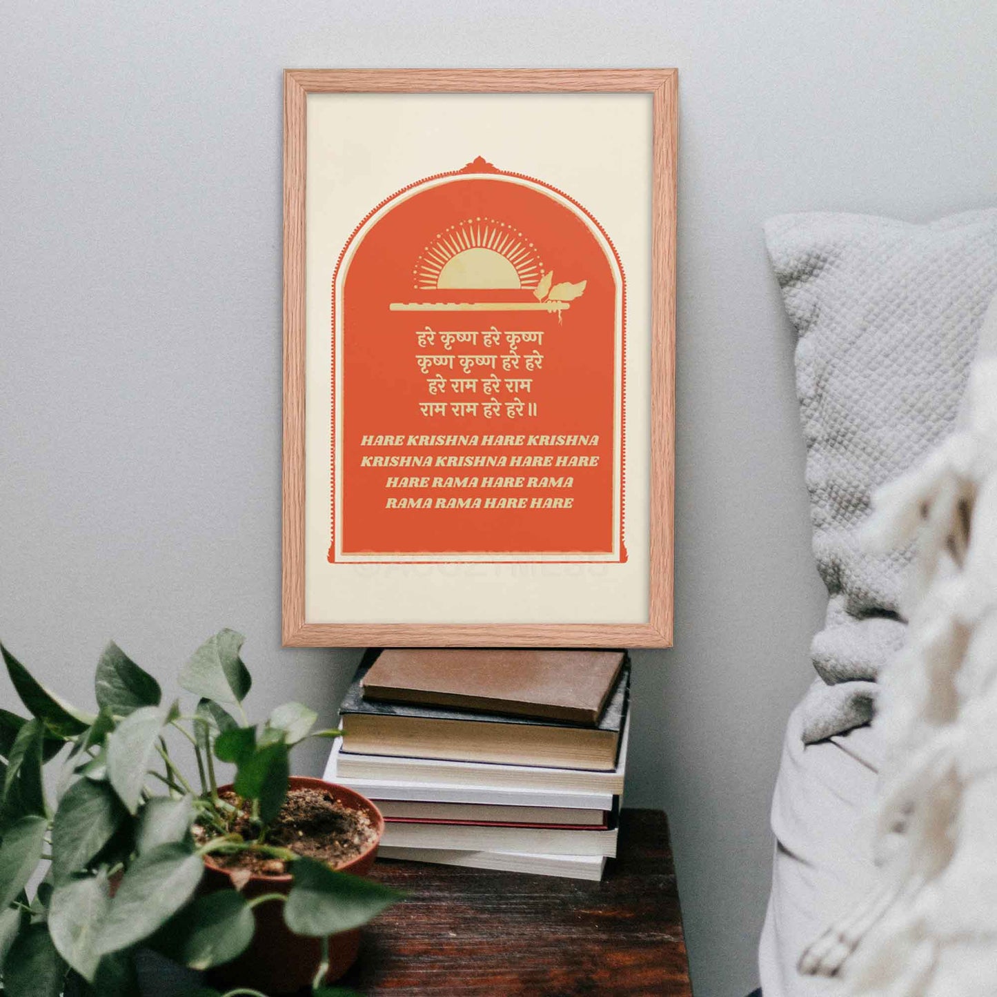 Hare Krishna poster in red and beige, featuring text in both English and Hindi and flute and sun art symbolizing Krishna, framed in oakwood.