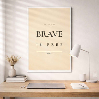 Minimalist  Stoic Quote Framed poster with 'Be who is brave, be free' quote on a wall above a desk.