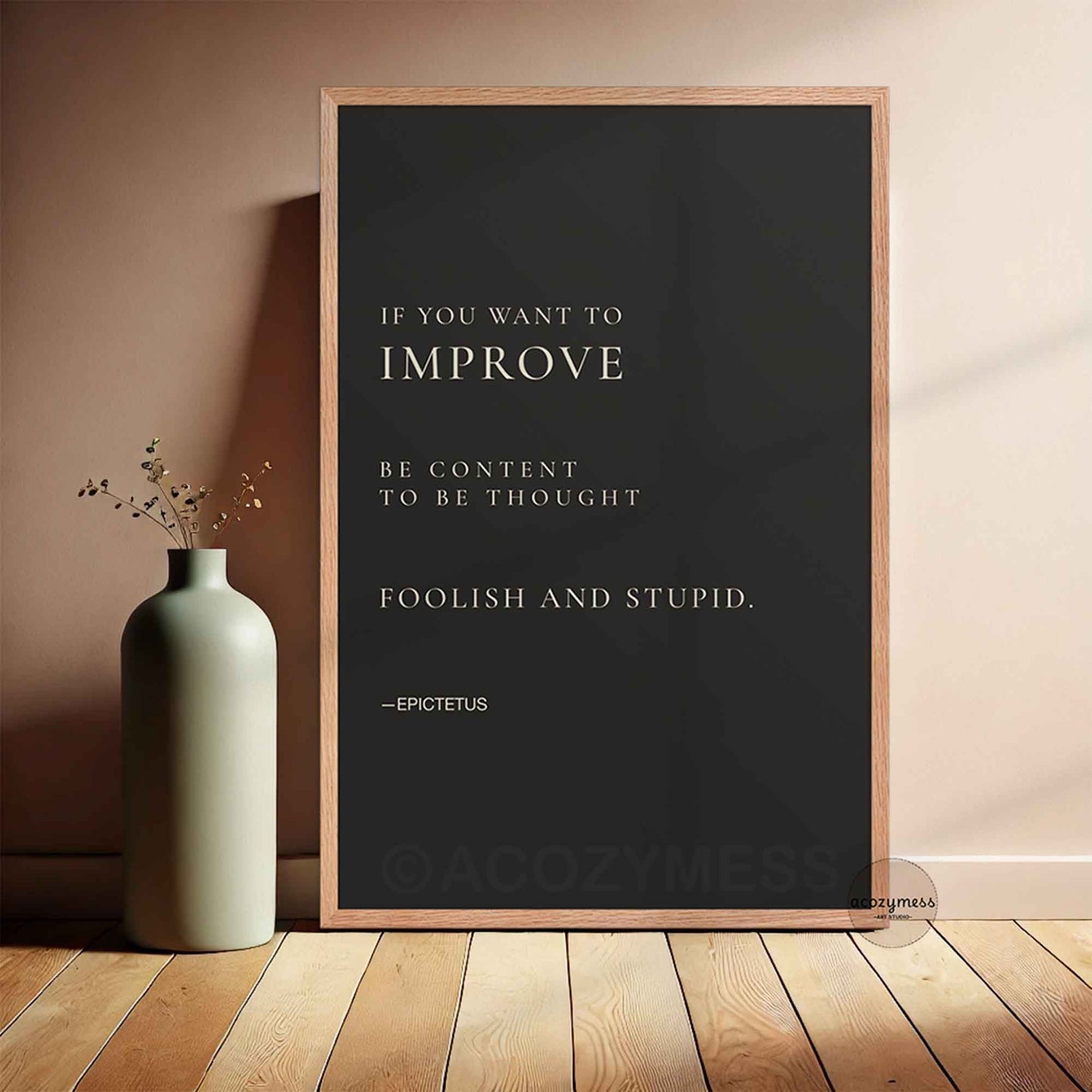 Framed poster with Epictetus quote on a wall next to a vase.