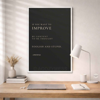 White Framed quote by Epictetus on a wall above a desk.