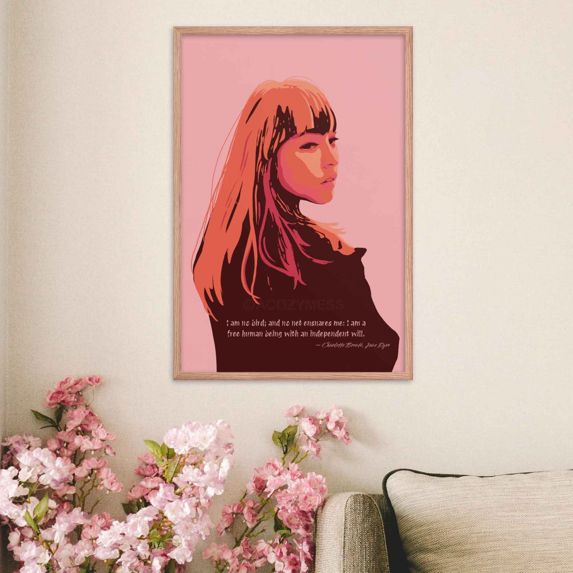 Art print of a woman in pink, orange, and brown tones with a quote from Jane Eyre reading 'I am no bird; and no net ensnares me; I am a free human being, with an independent will,' in oakwood frame