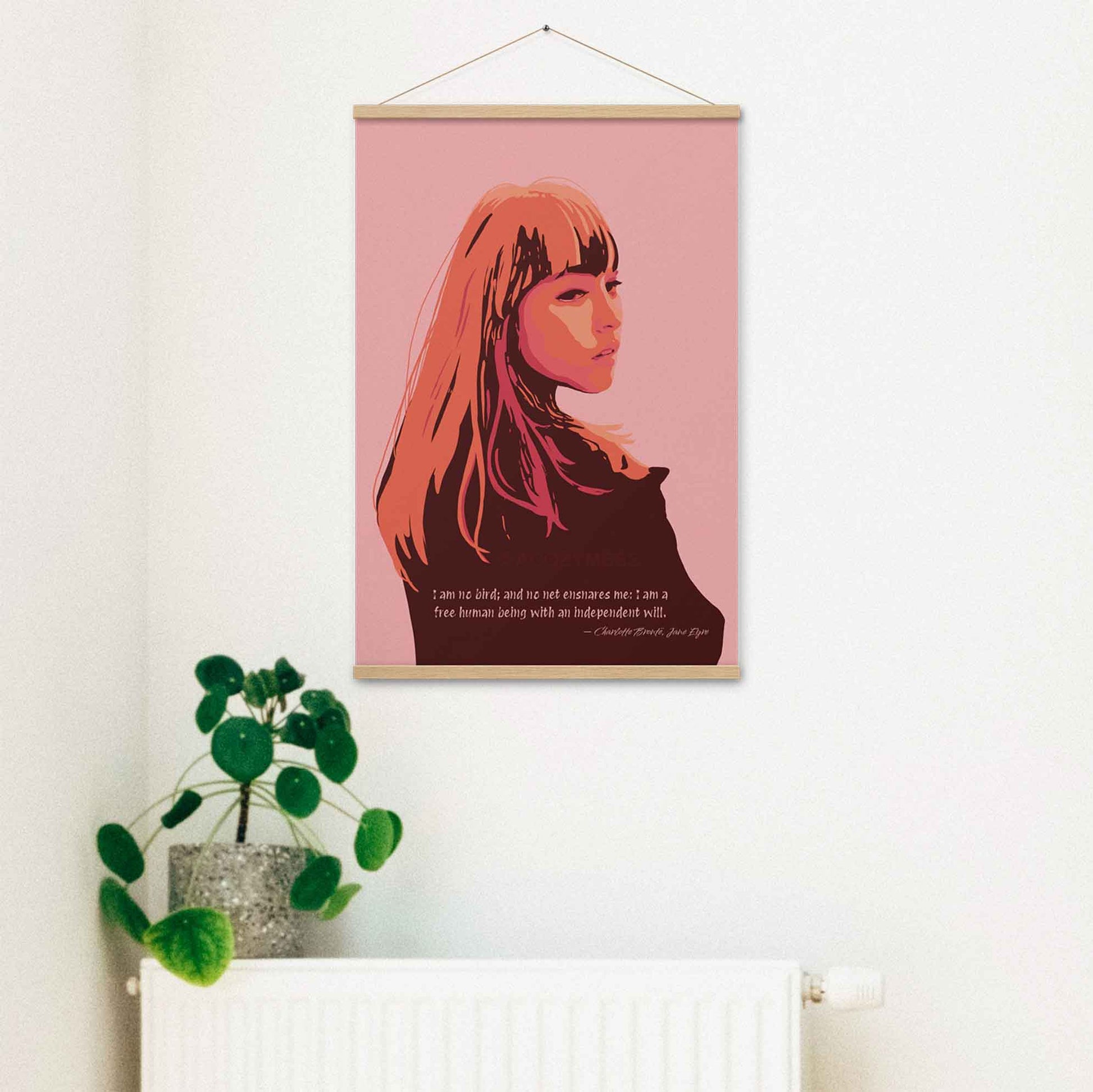 Art print of a woman in pink, orange, and brown tones with a quote from Jane Eyre reading 'I am no bird; and no net ensnares me; I am a free human being, with an independent will,' Print in hanging frame