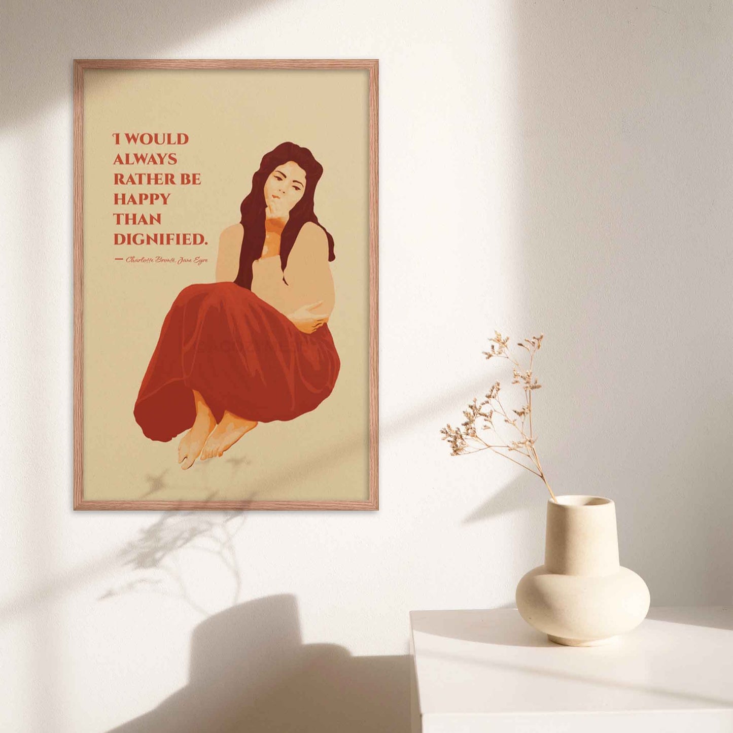 Art print featuring a woman illustration with the quote from Jane Eyre: 'I would always rather be happy than dignified,' designed in red and beige color hues in oak frame.