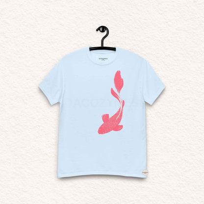 Light blue t-shirt with a pink fish design on a hanger against a light background