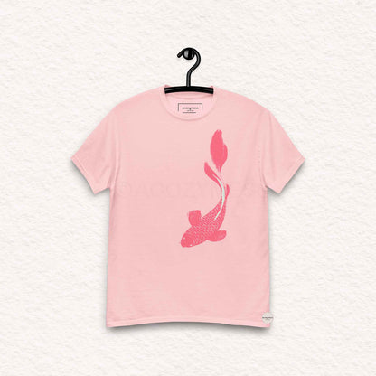 Pink t-shirt with a fish design on a hanger against a light gray background