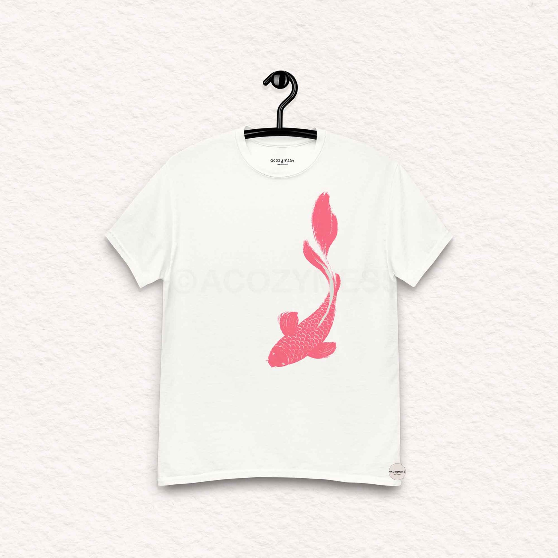 White t-shirt with pink fish design on a hanger against a white background