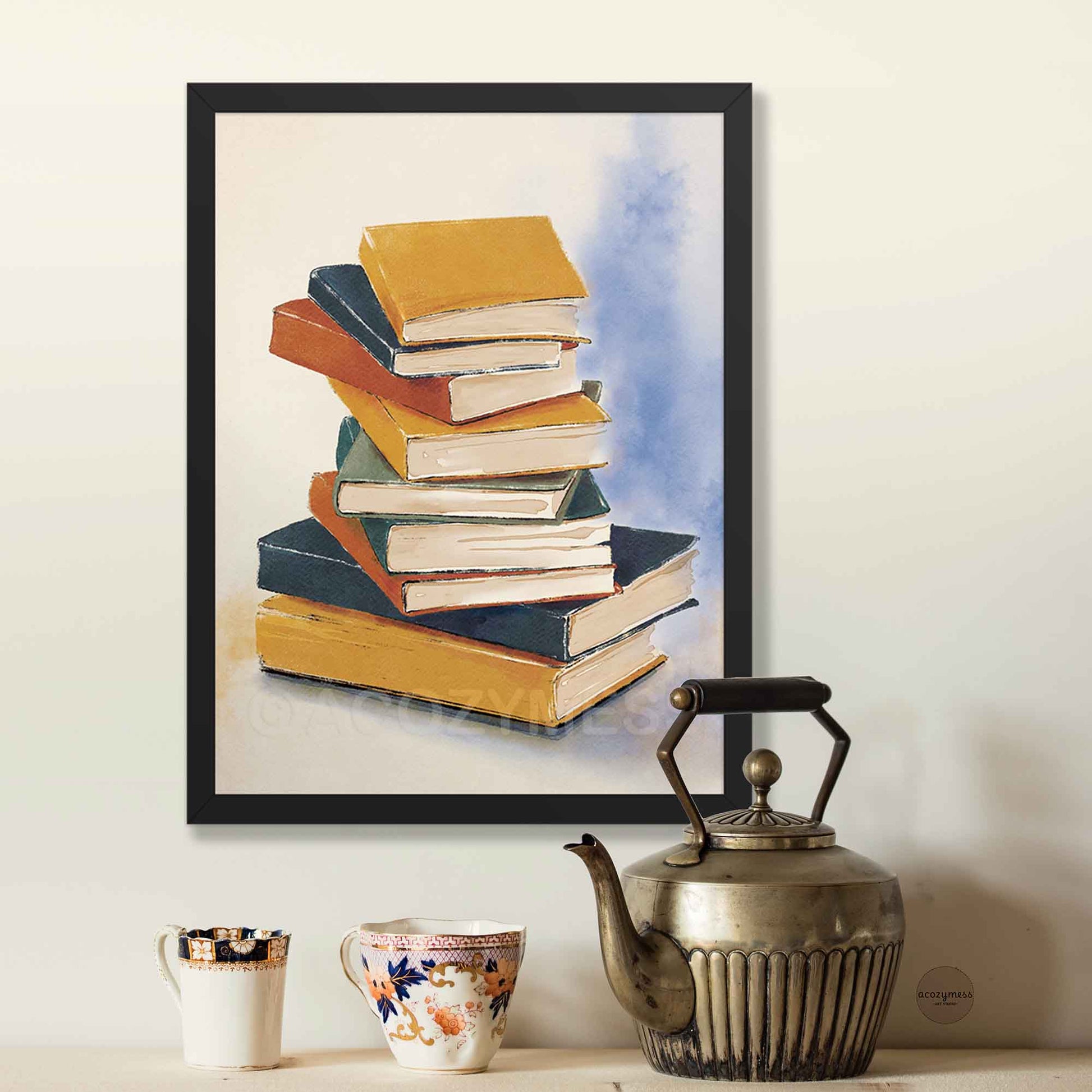 Framed artwork of stacked books on a wall above a table with a teapot and mugs.