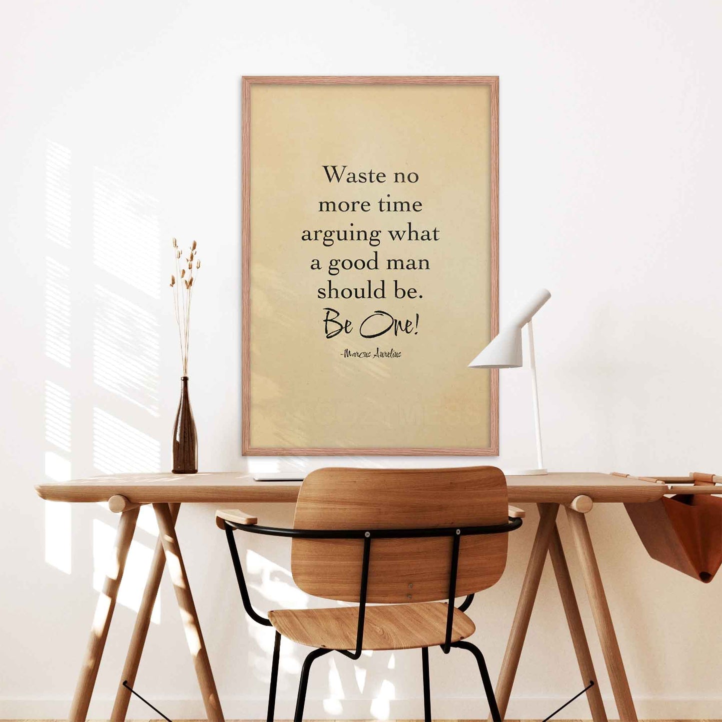 Black-on-beige literary print featuring the quote by Marcus Aurelius, styled with an old paper look and displayed in a black frame on a desk wall.