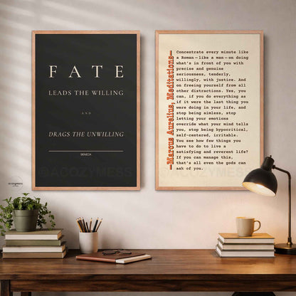Two framed stoic quotes prints on a wall above a wooden desk.