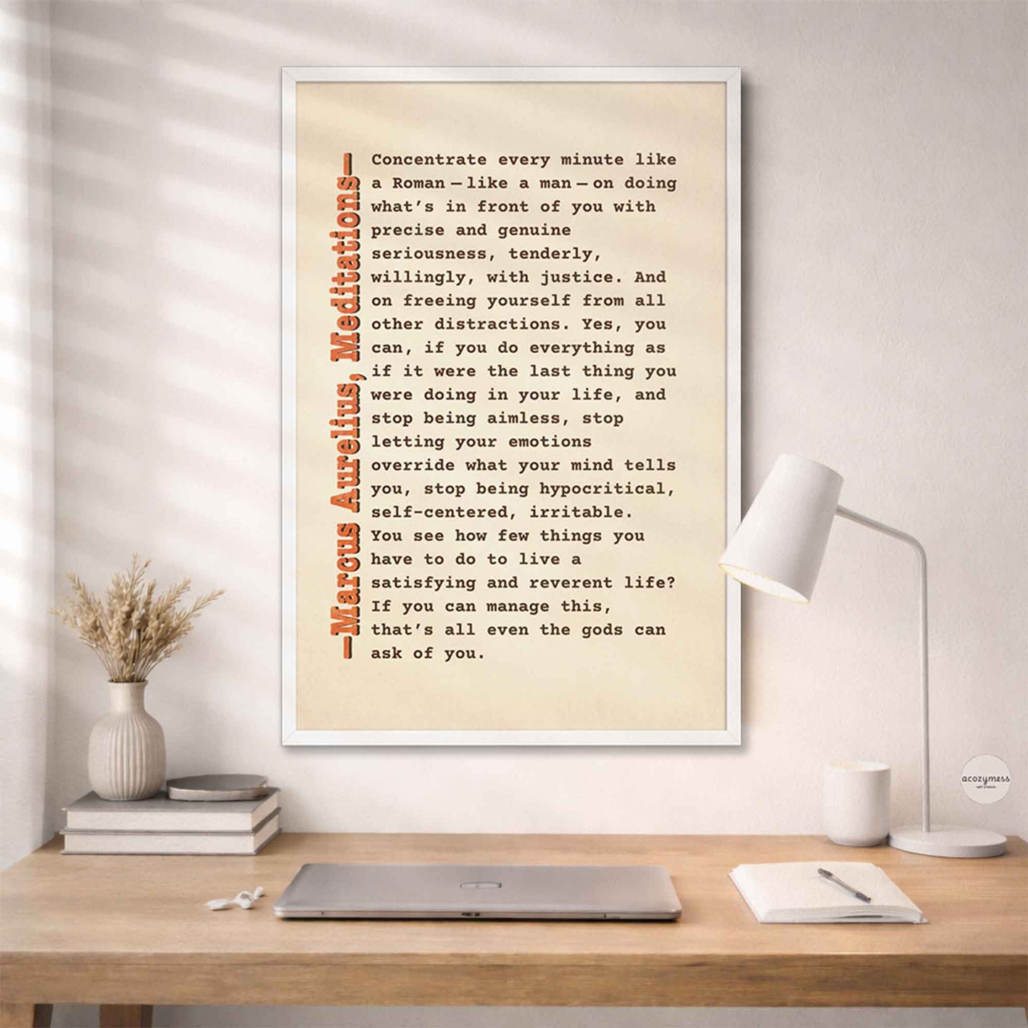 Marcus Aurelius Stoic quote wall art in white frame on beige background mounting on a wall above study desk.
