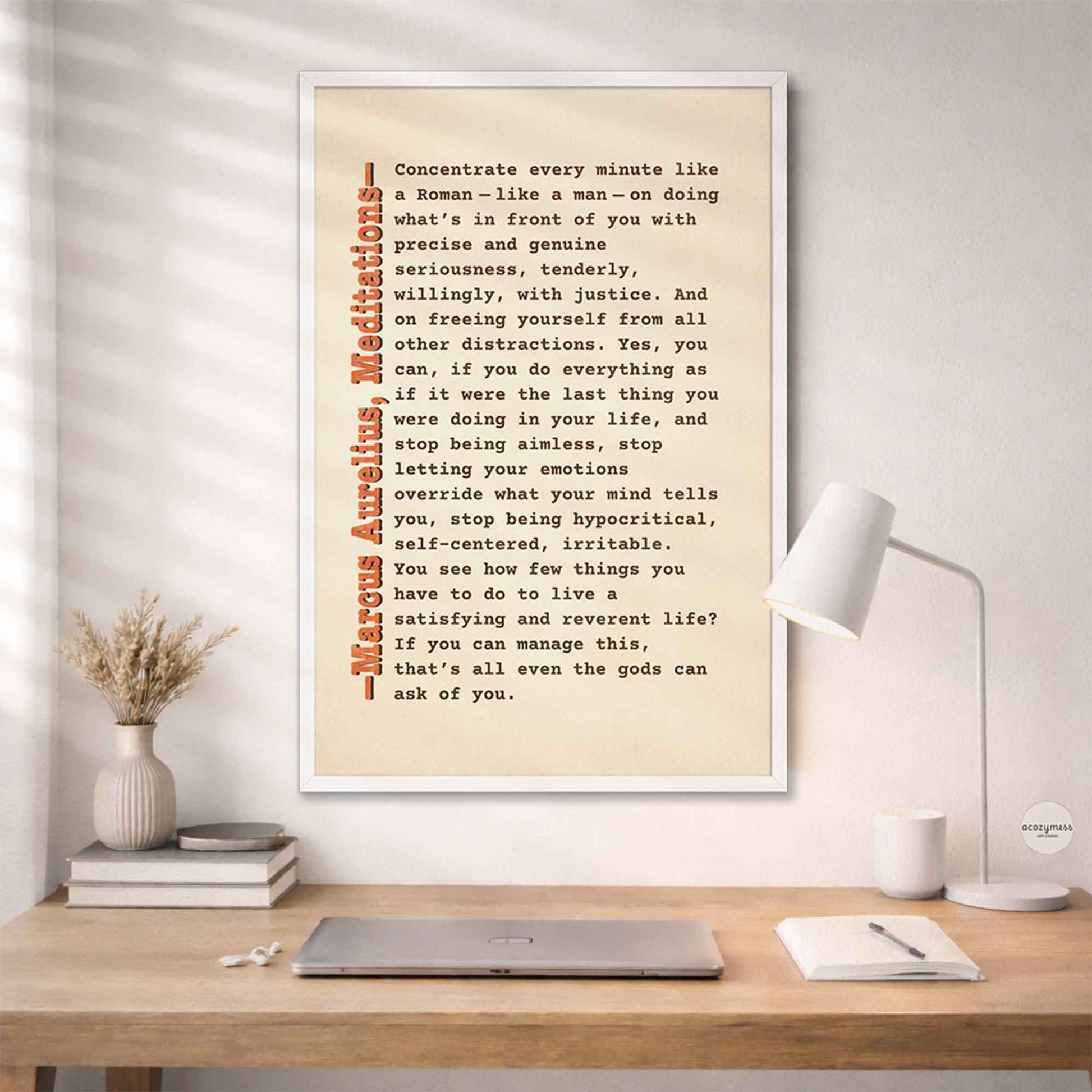 Marcus Aurelius Stoic quote wall art in white frame on beige background mounting on a wall above study desk.