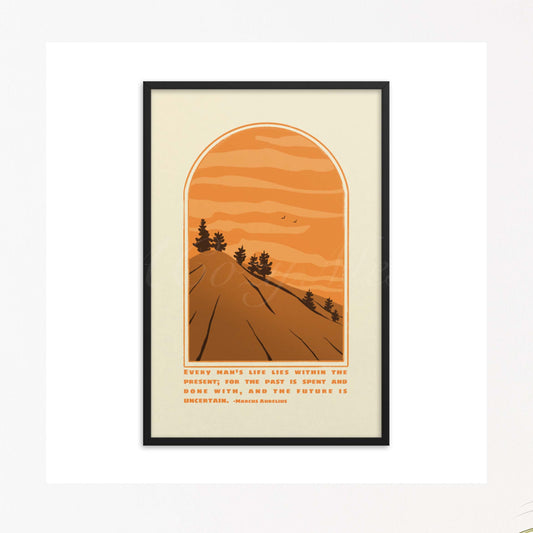 A framed art poster depicting an arch-shaped window view of a stylized landscape with a road leading towards the horizon, flanked by silhouetted pine trees against a backdrop of orange sky with layered clouds. At the bottom is a quote from Marcus Aurelius in a clean, legible font: "Every man's life lies within the present, for the past is spent and done with, and the future is uncertain." 