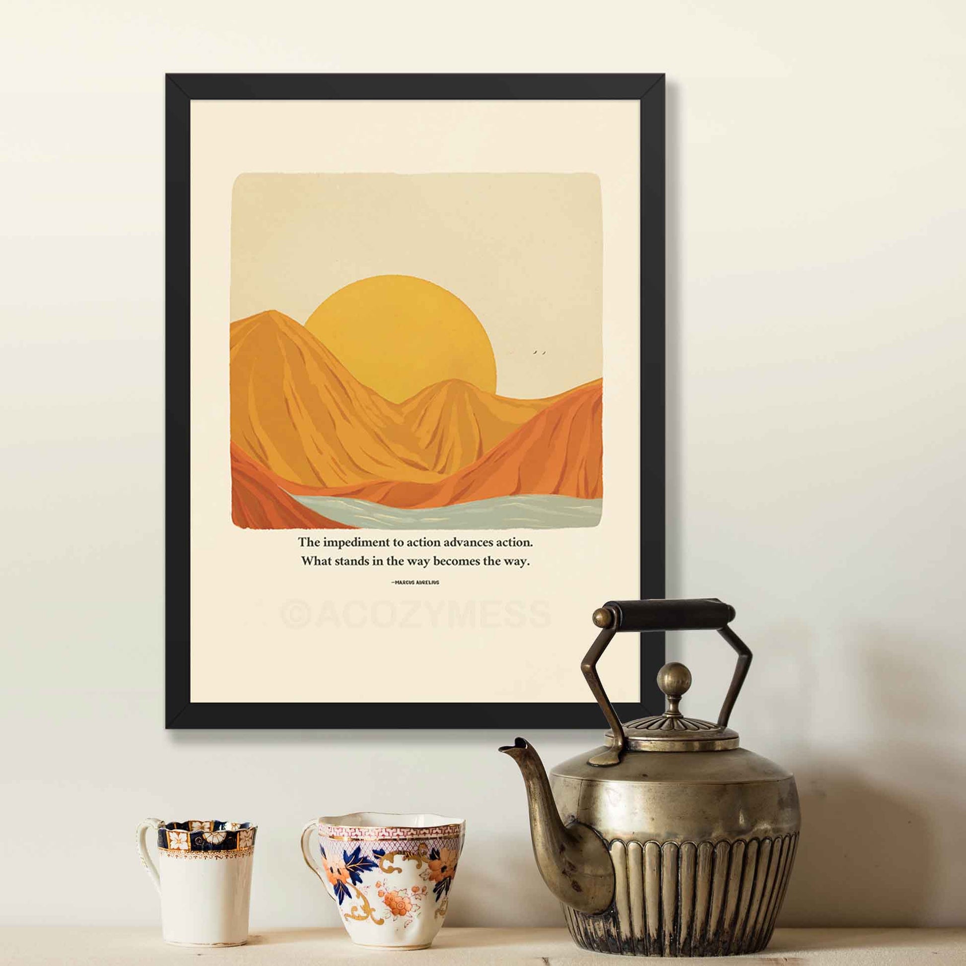 A motivational poster in black frame featuring Marcus Aurelius' quote, "The impediment to action advances action. What stands in the way becomes the way," alongside a warm-toned nature illustration of a sun rising behind mountains with a flowing river. 