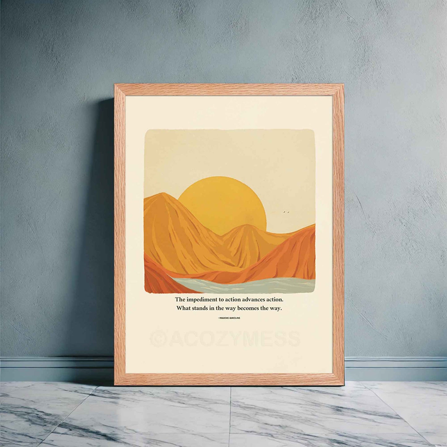 A motivational poster in oakwood frame featuring Marcus Aurelius' quote, "The impediment to action advances action. What stands in the way becomes the way," alongside a warm-toned nature illustration of a sun rising behind mountains with a flowing river. 