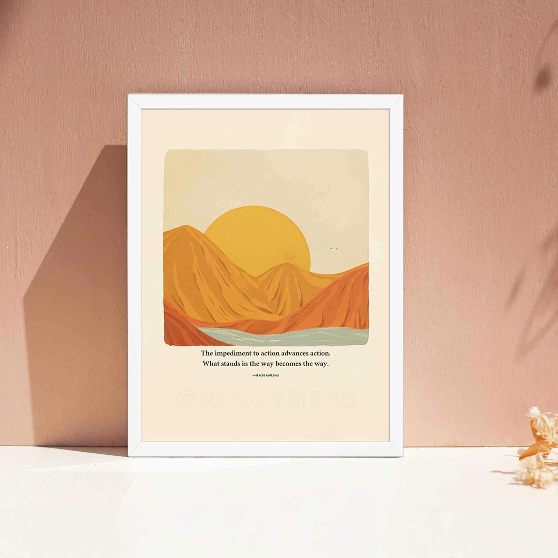 A motivational poster in white frame featuring Marcus Aurelius' quote, "The impediment to action advances action. What stands in the way becomes the way," alongside a warm-toned nature illustration of a sun rising behind mountains with a flowing river. 