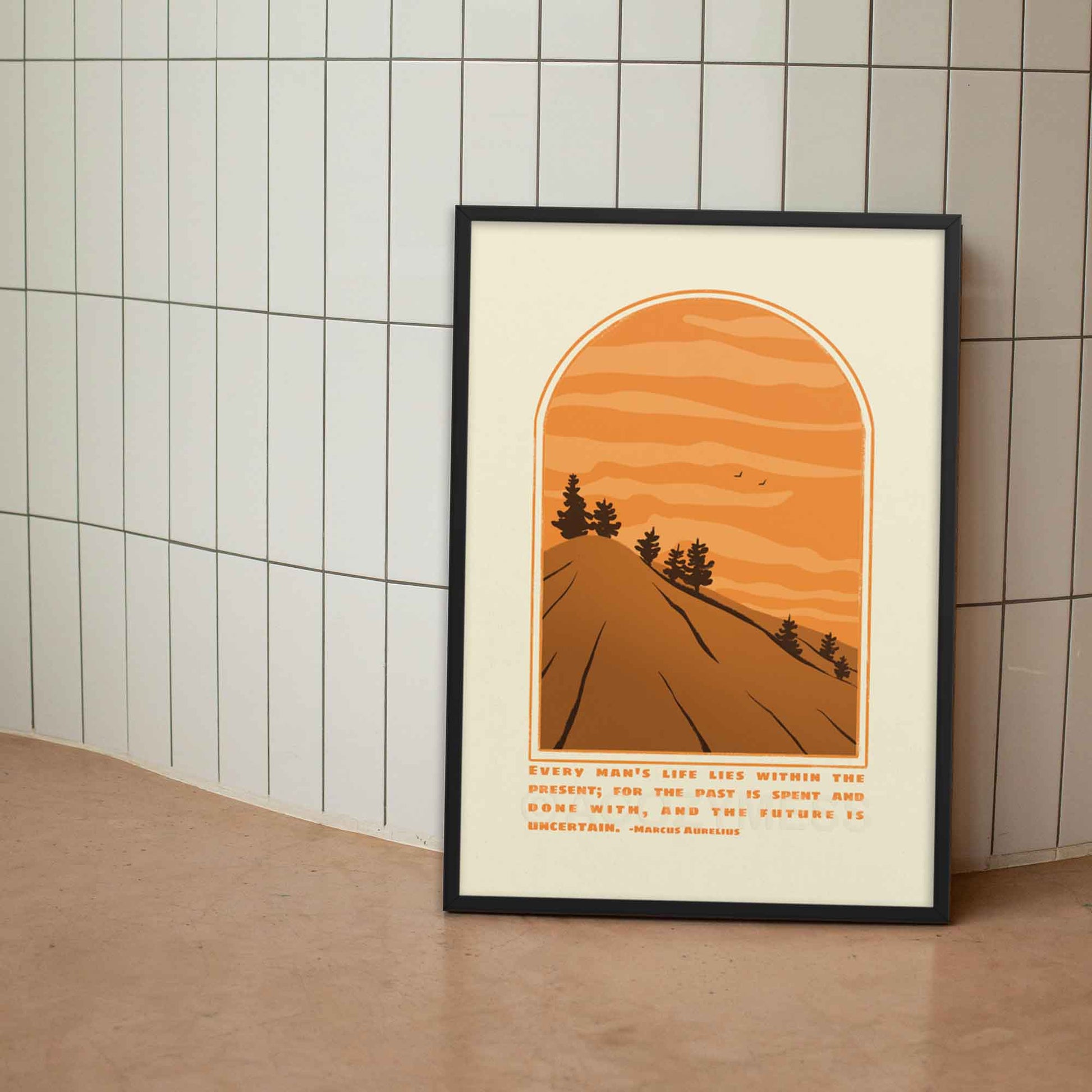 Marcus Aurelius Poster with quote on present moment with an illustration of a scenic mountain  view in beige, brown and orange colors displayed in black frame.