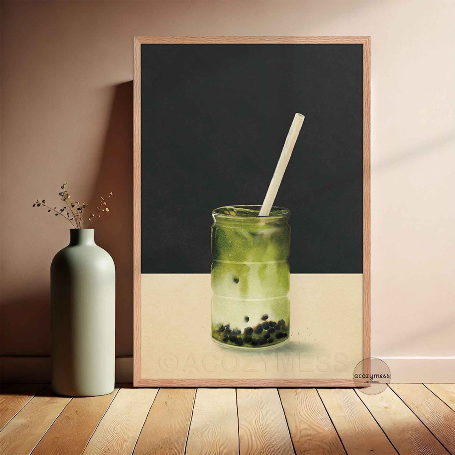 Oakwood Framed artwork of a green matcha drink with a straw in a glass jar on a black background, leaning against a wall.