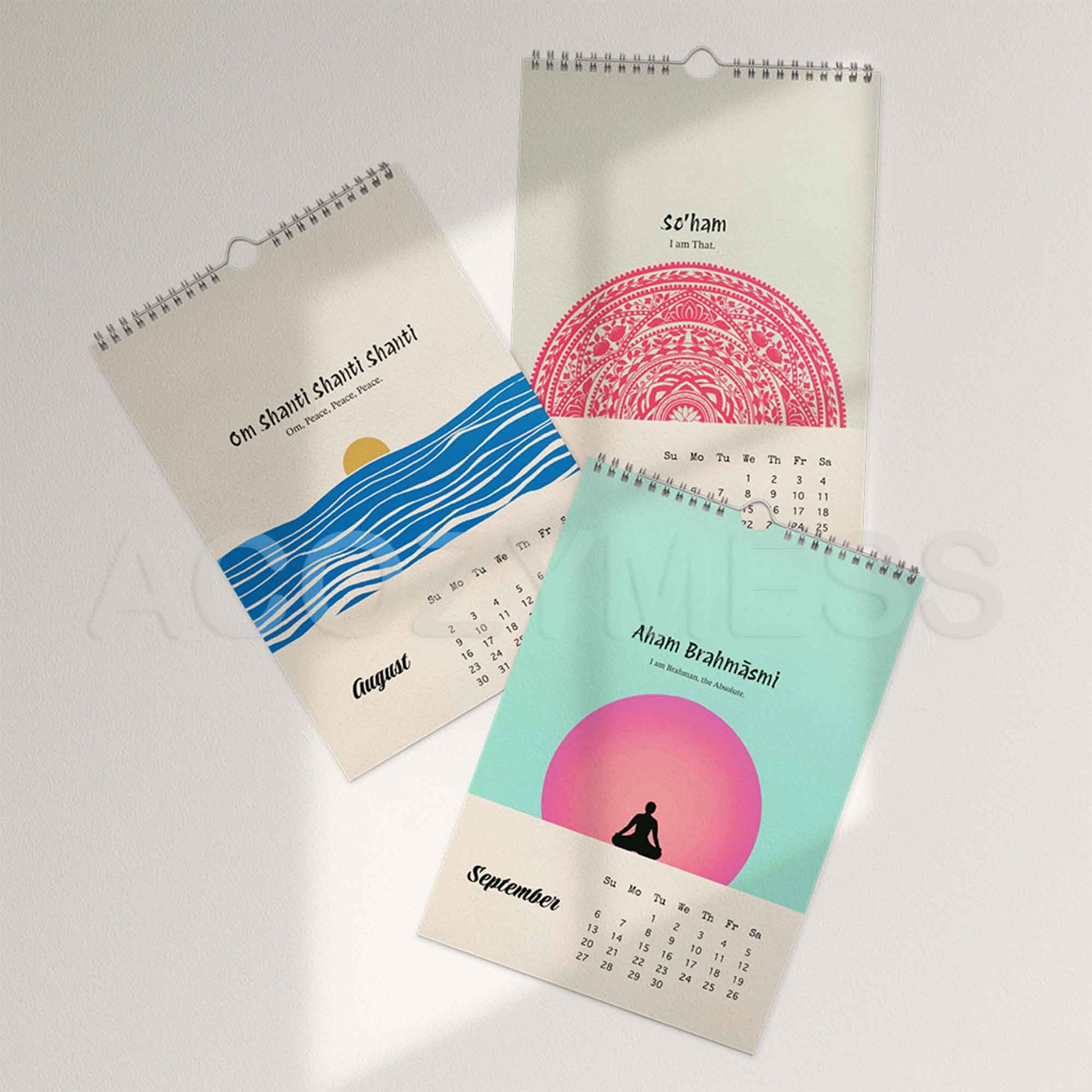 Three spiral-bound calendars pages of different months with  spiritual designs and mantras