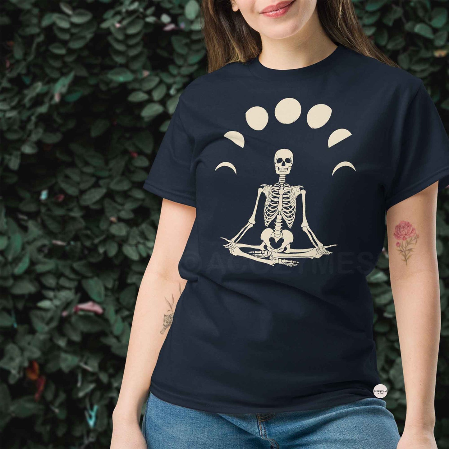 Woman wearing a navy blue t-shirt with a skeleton in a meditative pose design.