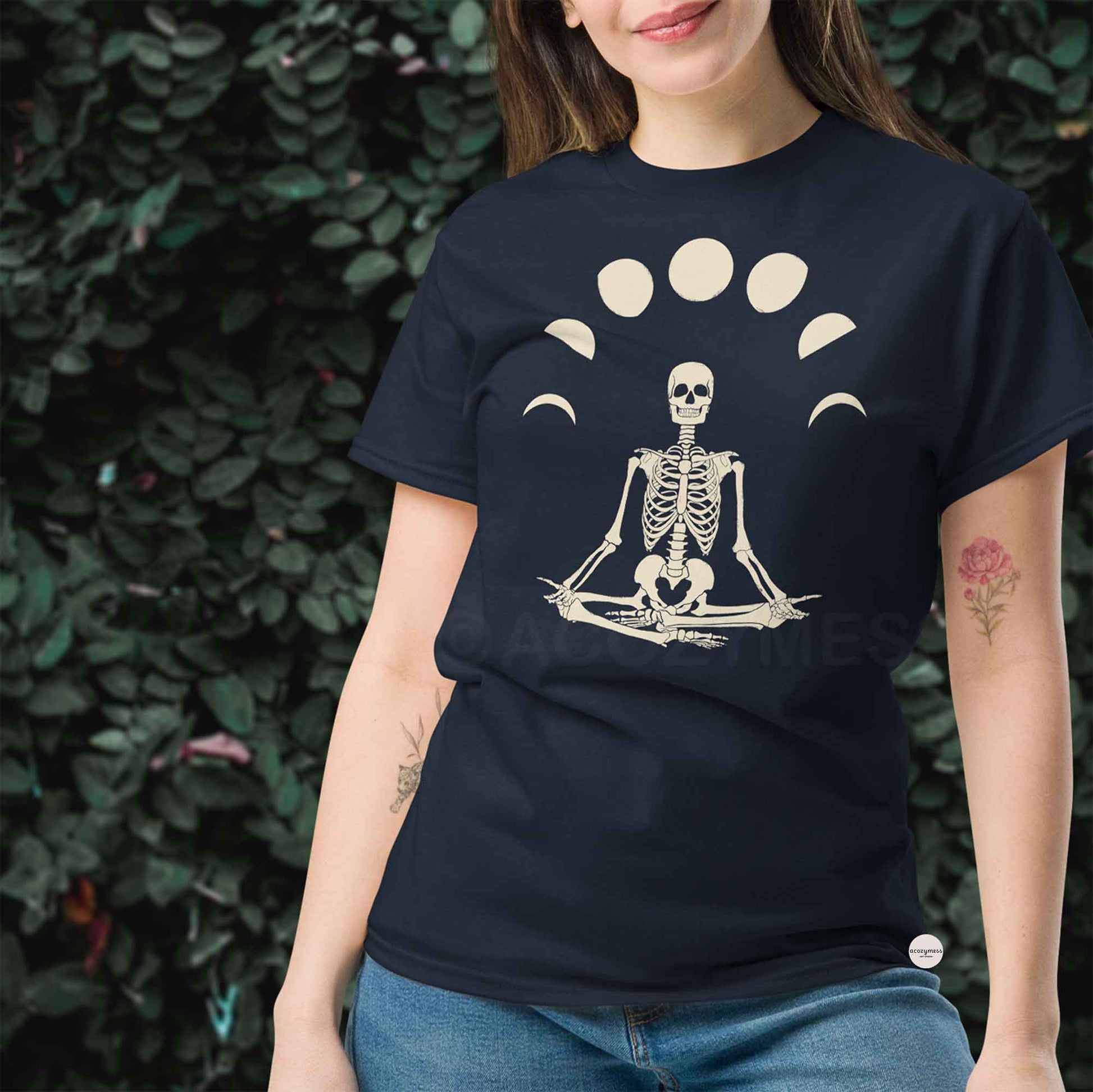 Woman wearing a navy blue t-shirt with a skeleton in a meditative pose design.