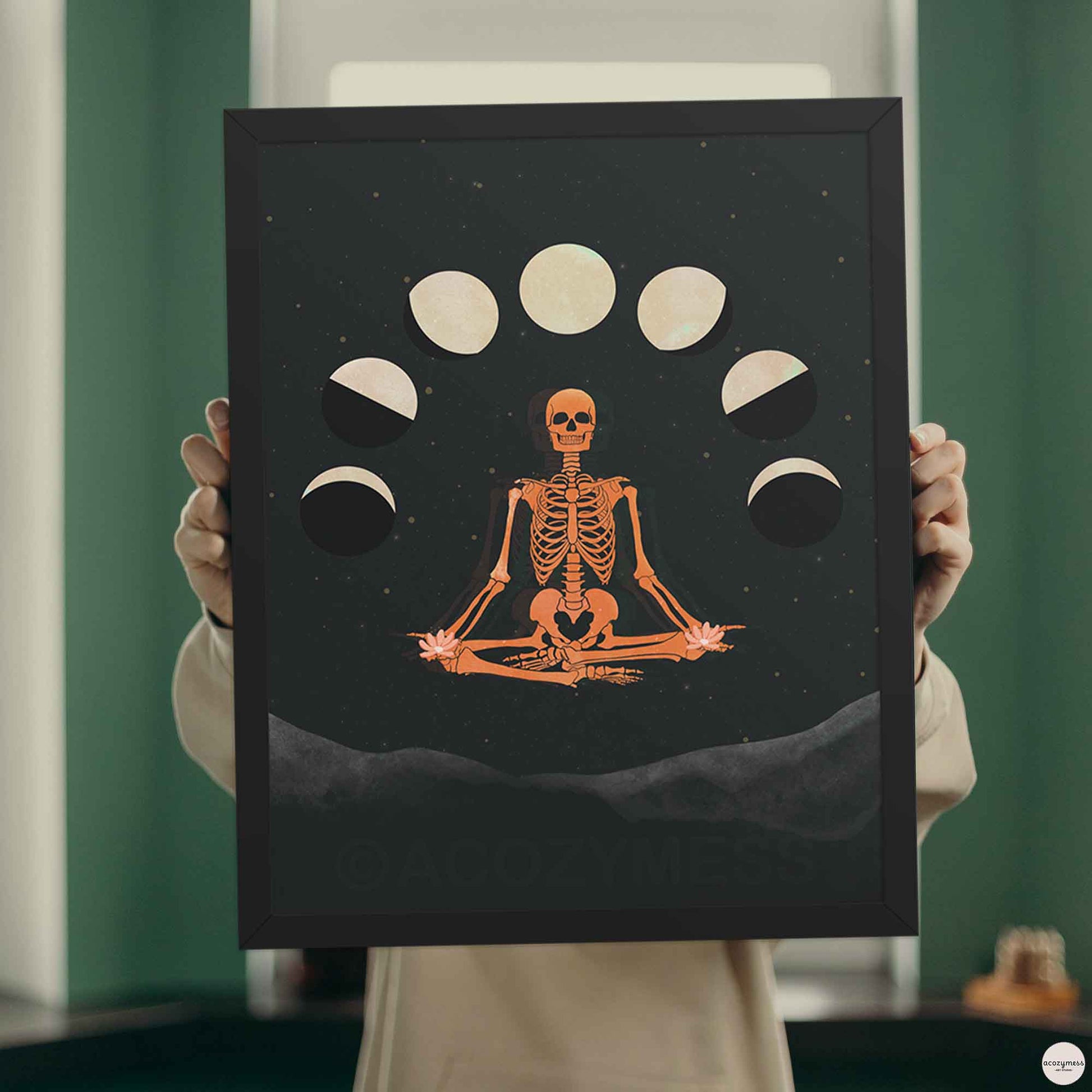 Spiritual skeleton wall art with moon cycles in black frame, adding contrast and depth to the dark celestial theme.