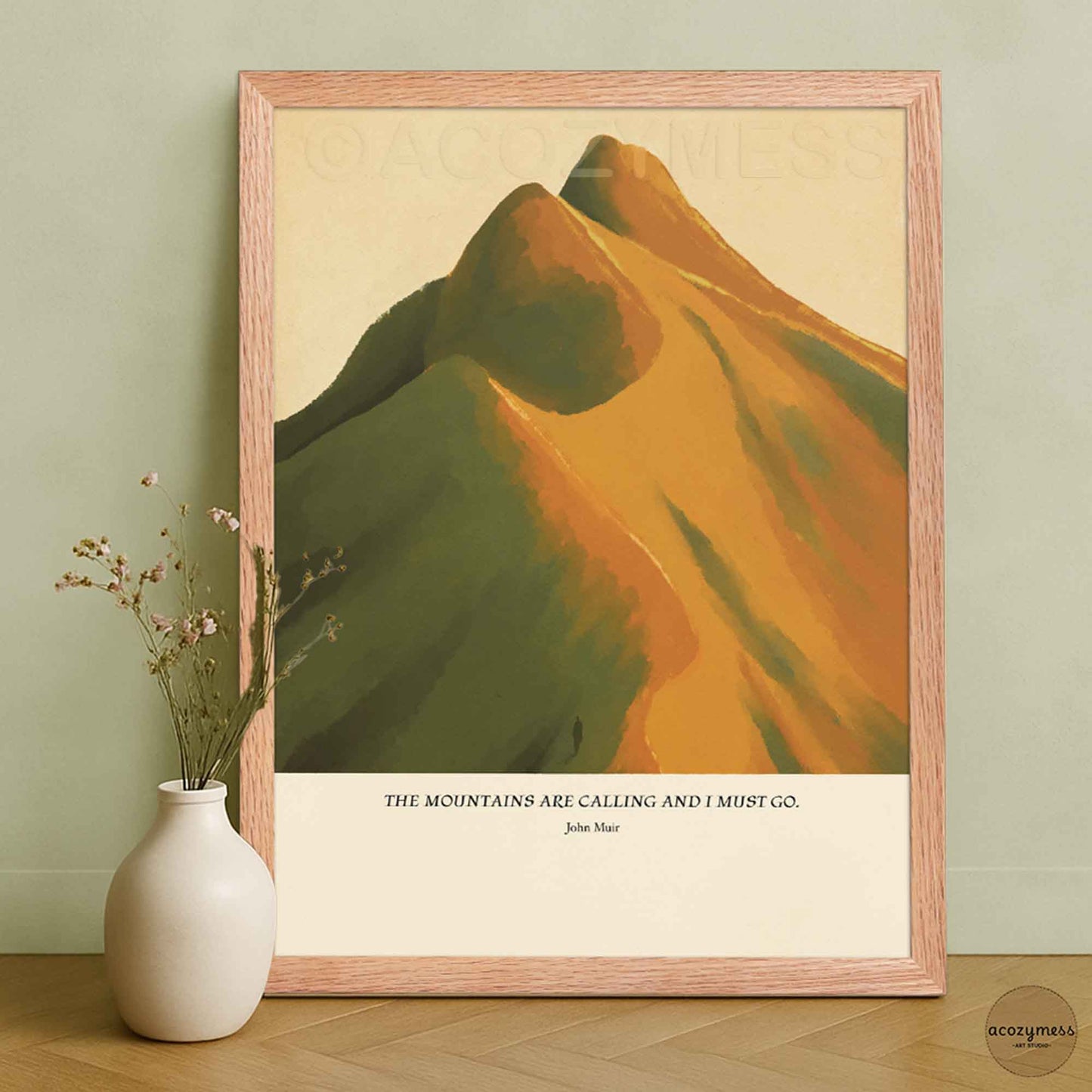 John Muir mountain quote wall art displayed in an oakwood frame, showing mountains illustrated in warm earthy hues.