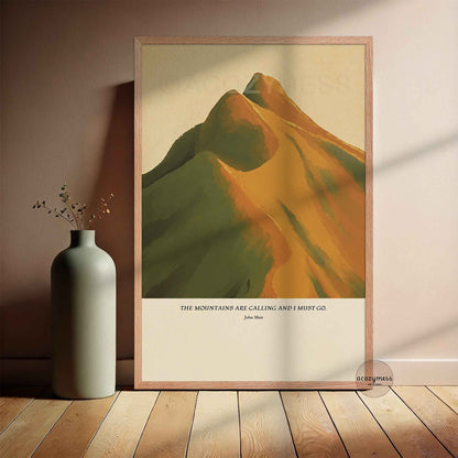 Oakwood framed poster featuring the quote “The mountains are calling and I must go” by John Muir, with warm-toned mountain landscape artwork.