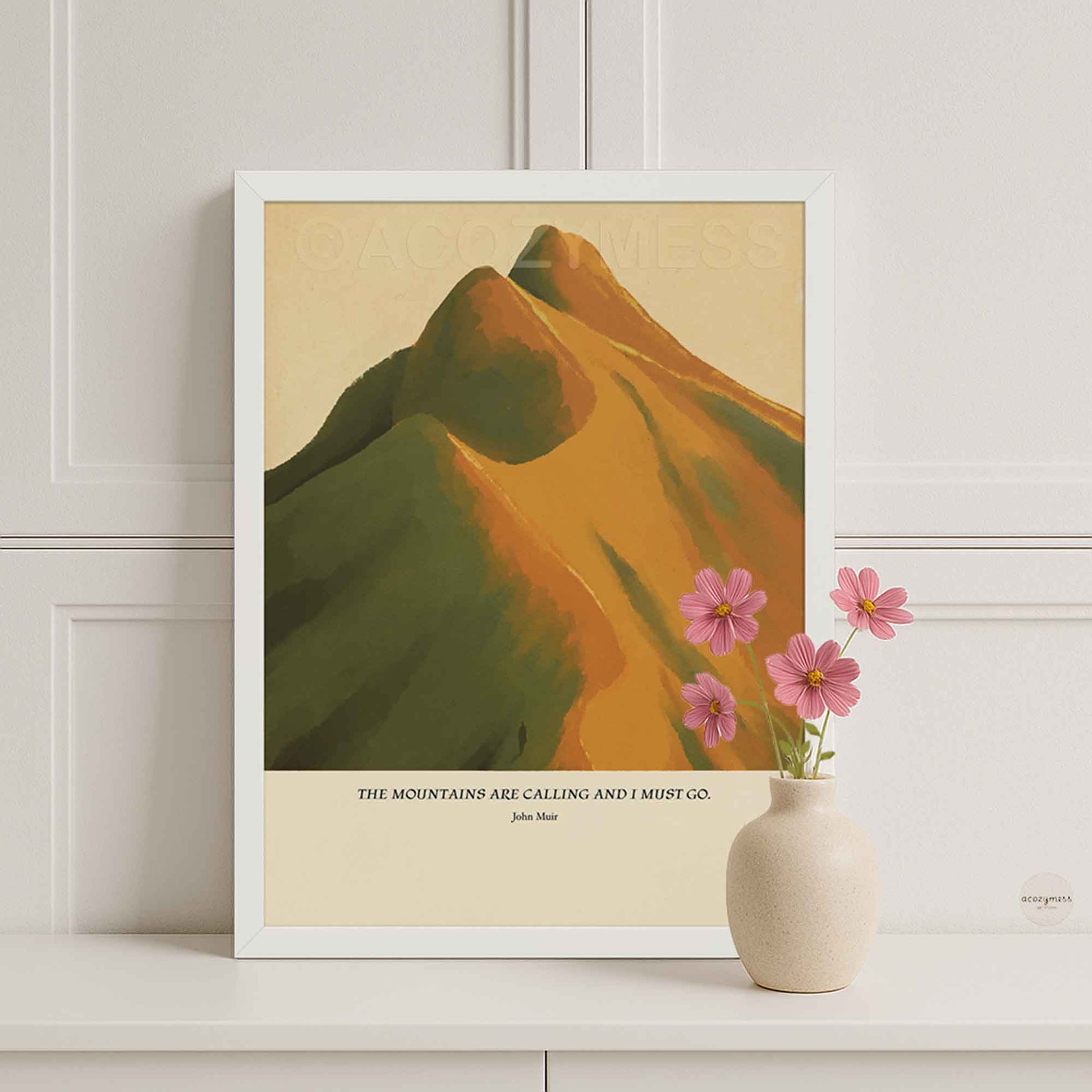 White framed John Muir quote poster with “The mountains are calling and I must go,” paired with warm mountain artwork.