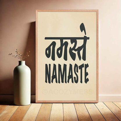 A oakwood-framed typography poster featuring the word Namaste in both Hindi (नमस्ते) and English, displayed in bold black font on a beige background. The minimalist design symbolizes peace, respect, and spiritual connection, making it ideal for yoga studios and mindful spaces.