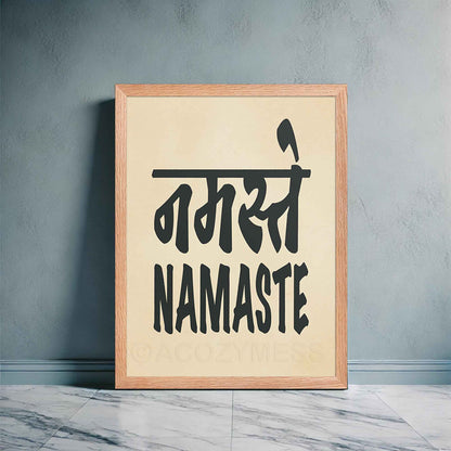 An oakwood -framed typography poster featuring the word Namaste in both Hindi (नमस्ते) and English, displayed in bold black font on a beige background. 