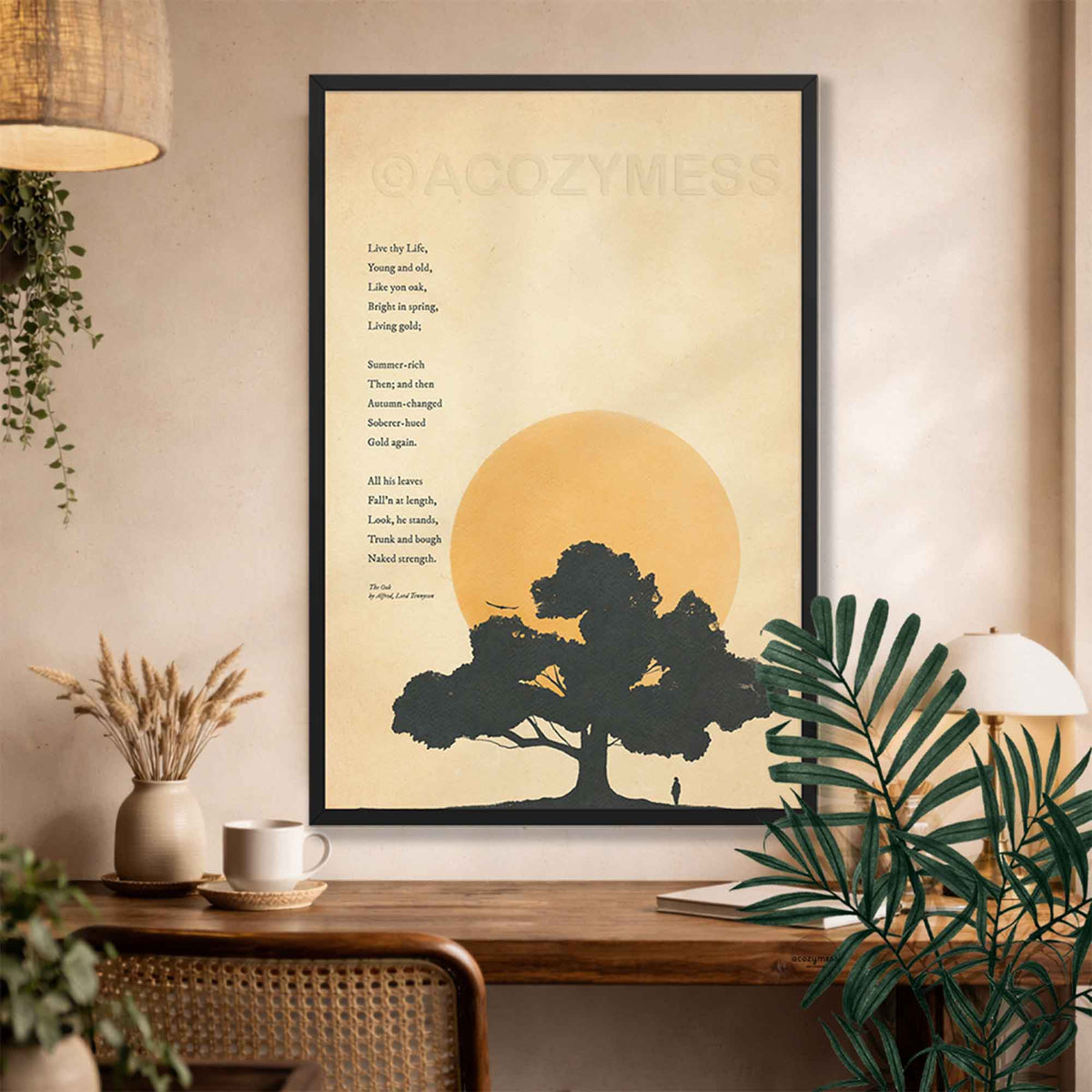 Minimalist Black framed art print of Alfred Lord Tennyson's poem The Oak, showing a black oak tree silhouette and ochre sun on vintage warm beige paper on a desk wall.