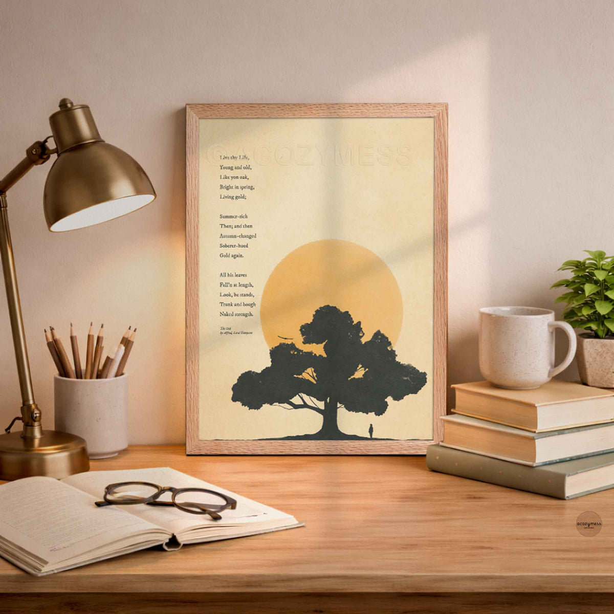 Minimalist oakwood color framed art print of Alfred Lord Tennyson's poem The Oak, showing a black oak tree silhouette and ochre sun on vintage warm beige paper on a desk displayed in an office decor.