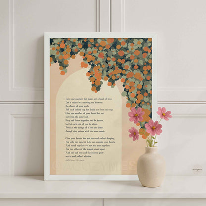 A white framed art print featuring a poem on a cream background with a floral illustration in orange.