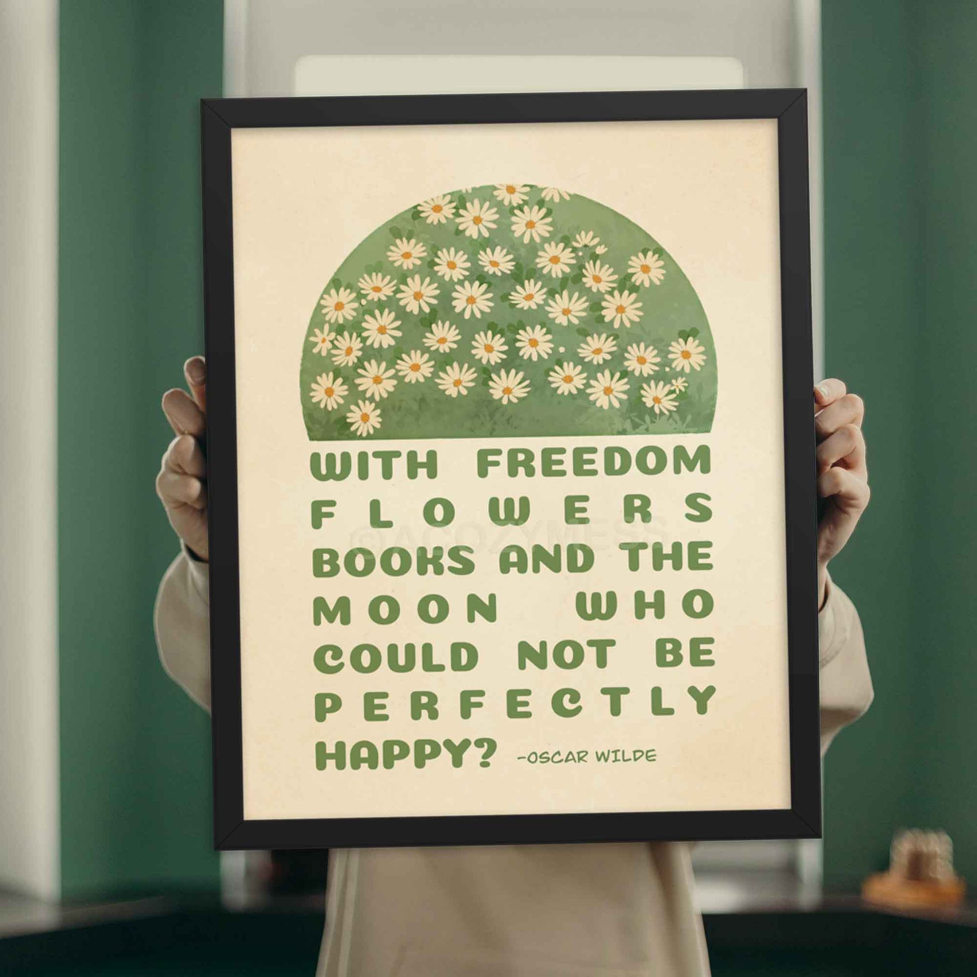 Poster featuring Oscar Wilde's quote, With freedom, flowers, books, and the moon, who could not be perfectly happy? with an illustration of white flowers on green and beige, displayed in black frame.