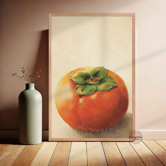 Framed artwork of a persimmon fruit on a wall next to a vase with dried flowers.