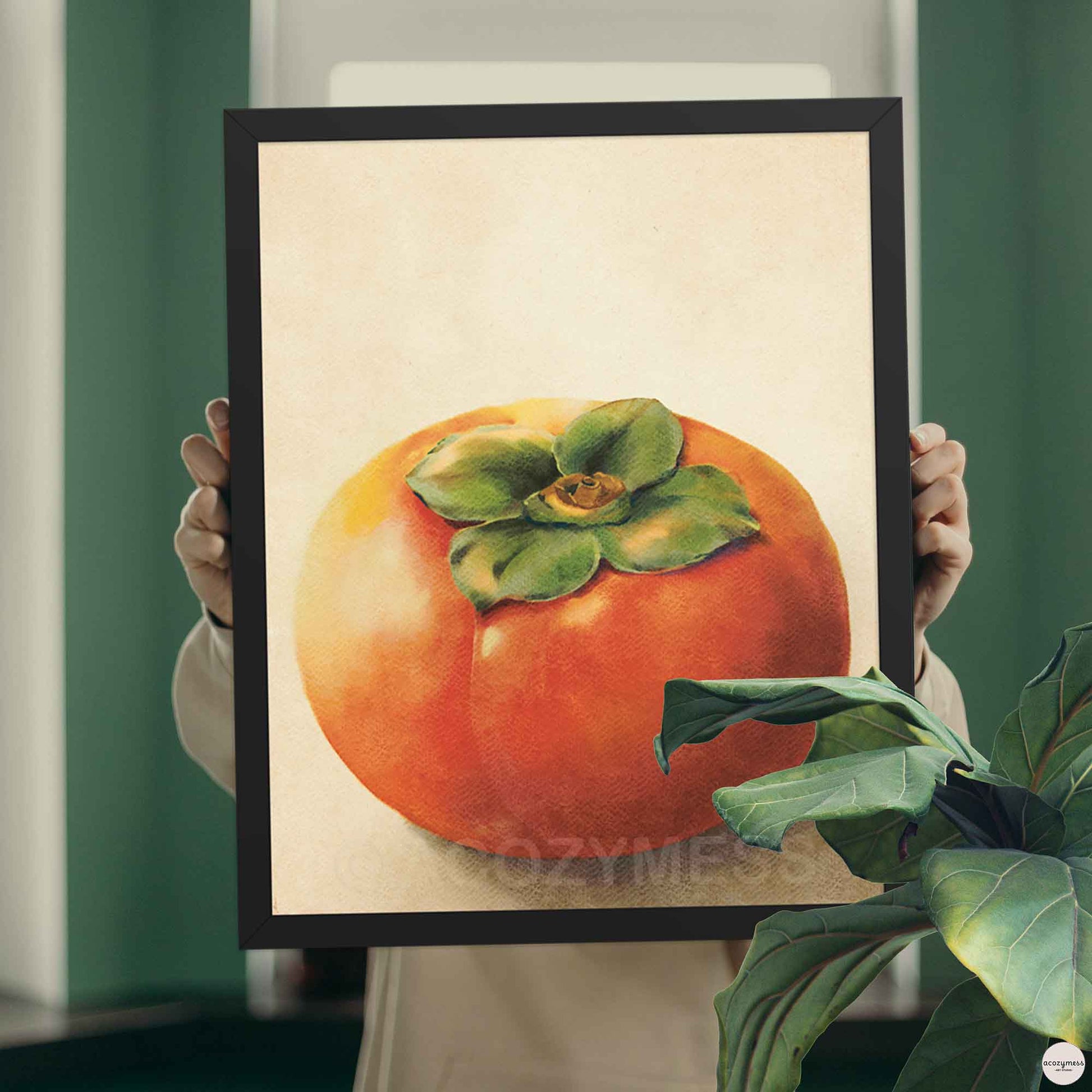 Persimmon poster in a black frame, orange fruit with green leaves centered on soft beige background.