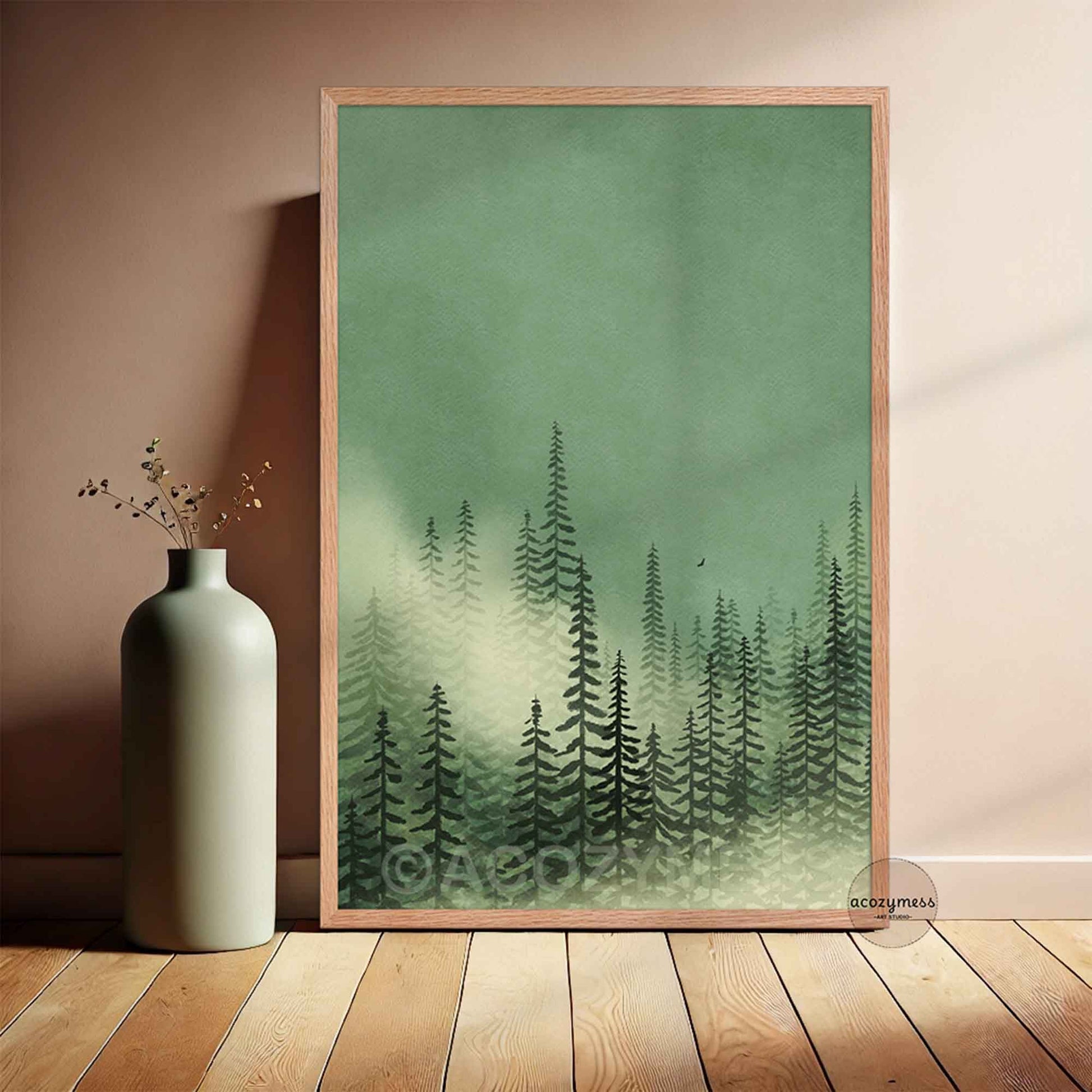 Misty pine forest wall art in green tones displayed in natural oakwood frame against neutral wall