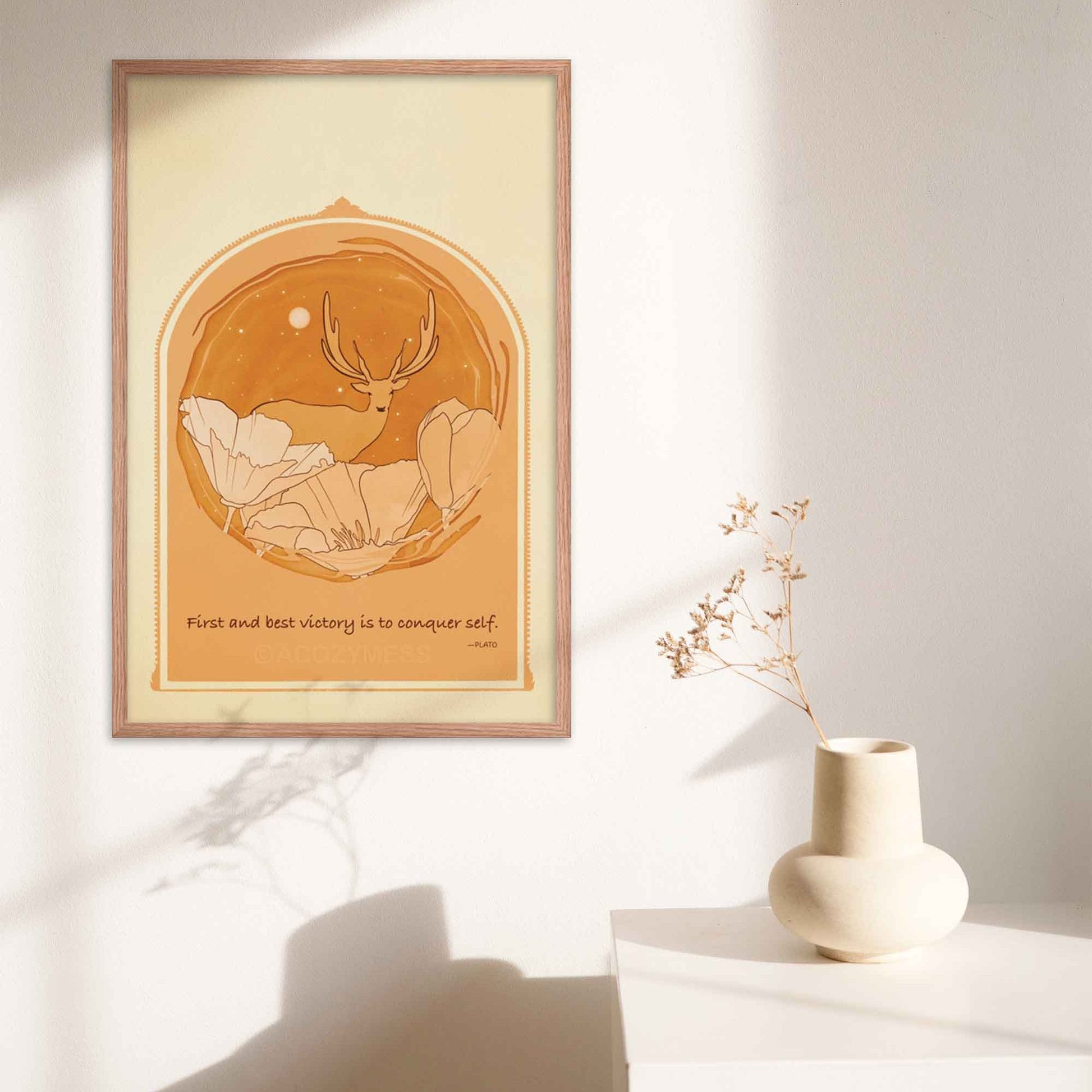 Art print featuring Plato's quote 'The first and best victory is to conquer self' alongside an illustration of a deer among flowers, done in yellow, orange and brown, framed in oakwood