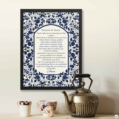 Prayer of St. Francis wall art displayed in a sleek black frame, featuring a floral design in dark blue on  light beige background for spiritual decor.