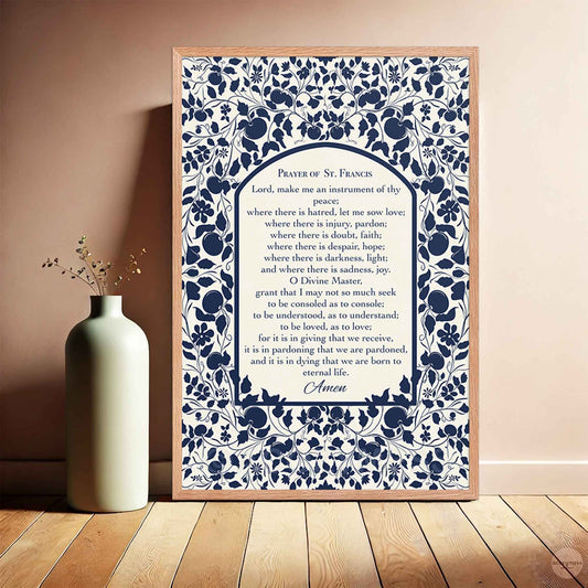 Prayer of St. Francis print in a warm oakwood frame, with a botanical blue design on a  light beige backdrop.