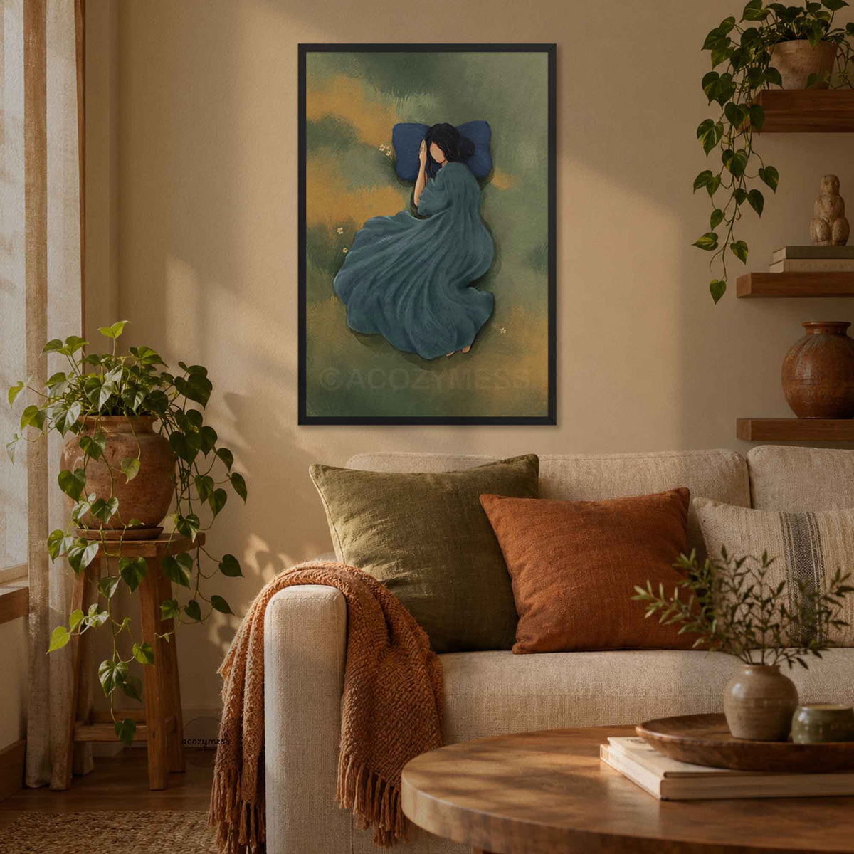Contemporary black frame showcasing a  art print of a serene woman resting in an olive green meadow draped in a flowing blue gown, displayed in a cozy earthly living room setting.