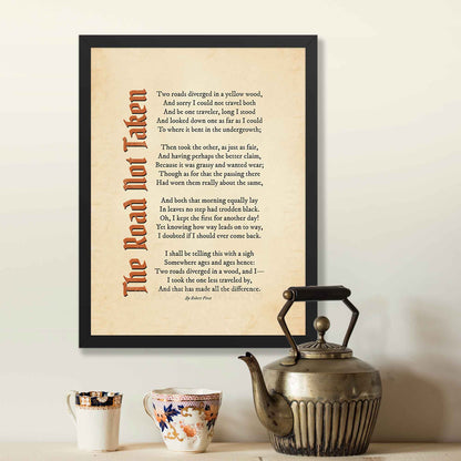 A vintage-style poster featuring Robert Frost’s iconic poem, The Road Not Taken printed on an aged, old-paper background, in a black frame.